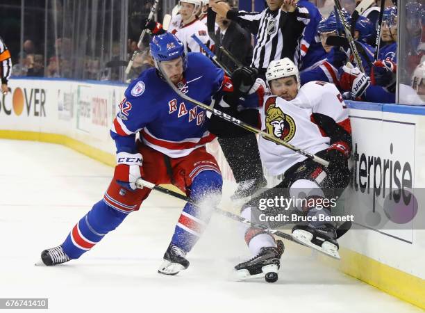 Brendan Smith of the New York Rangers checks Cody Ceci of the Ottawa Senators into the boards during the third period in Game Three of the Eastern...