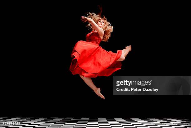 dancer in red dress in the air - entertainer stock pictures, royalty-free photos & images