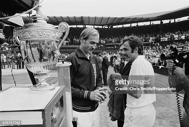 Victorious Australian tennis player John Newcombe pictured talking with defeated American tennis player Stan Smith beside the Gentlemen's Singles...