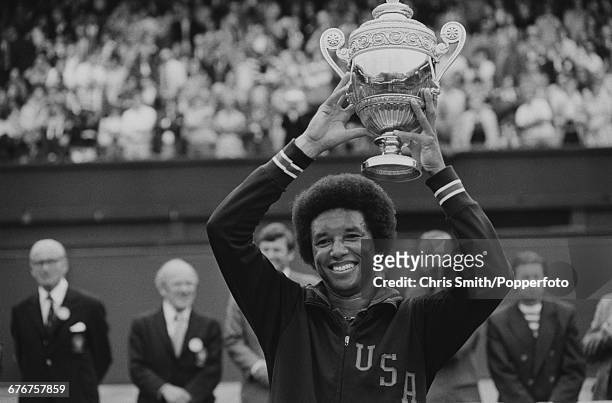 Victorious American tennis player Arthur Ashe holds up the Gentlemen's Singles Trophy after winning the final of the Men's Singles tournament against...