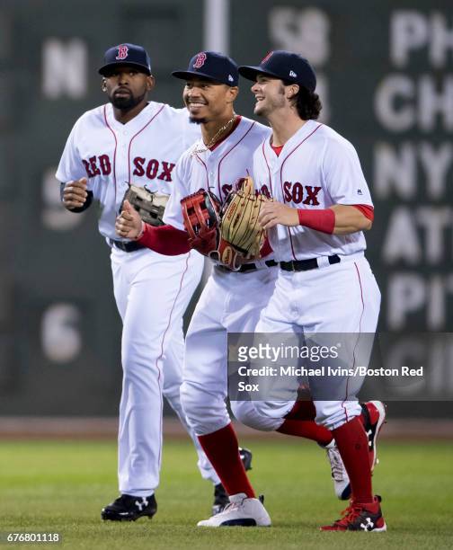 Jackie Bradley Jr. #19, Mookie Betts and Andrew Benintendi of the Boston Red Sox run off the field after a 5-2 win over the Baltimore Orioles at...
