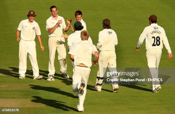 Surrey's Tim Linley celebrates taking the wicket of Warwickshire's Ateeq Javid with his team mates