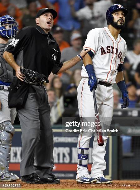 Marwin Gonzalez of the Houston Astros and home plate umpire Pat Hoberg watch Gonzalez's grand slam during the eighth inning against the Texas Rangers...