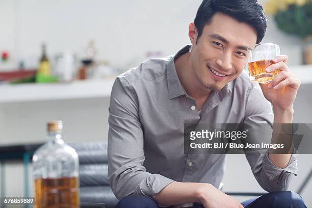 young man enjoying fine wine - bottles glass top stockfoto's en -beelden