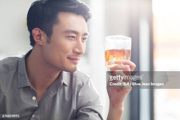 young man enjoying fine wine - cognac glass stock-fotos und bilder