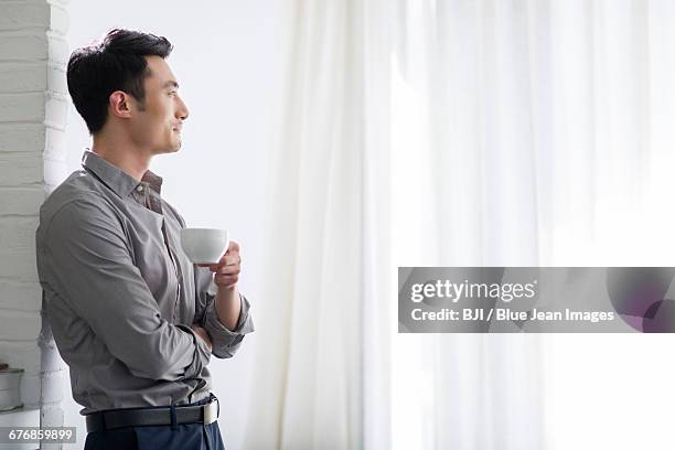 young man drinking coffee - design studio wall stock pictures, royalty-free photos & images