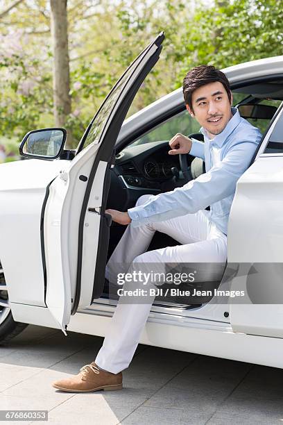 young man opening car door - open car door stock pictures, royalty-free photos & images