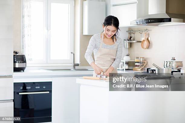 young woman making cookies in kitchen - woman front and back stock-fotos und bilder