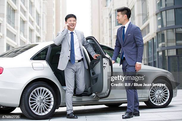 confident businessman getting off car - management car smartphone stock pictures, royalty-free photos & images