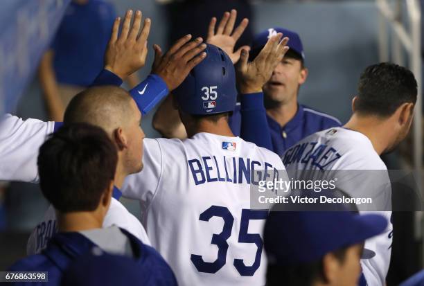 Cody Bellinger of the Los Angeles Dodgers is congratulated by teammates after scoring in the second inning on a single to left field by teammate Alex...