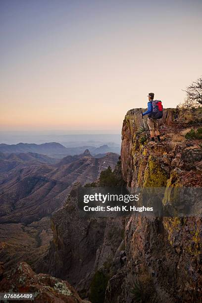 backpacker looking out from ridge at dusk, big bend national park, texas, usa - big bend national park stock pictures, royalty-free photos & images