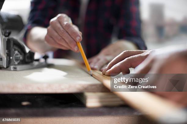close up of carpenters marking measurements in furniture making workshop - customized stock-fotos und bilder
