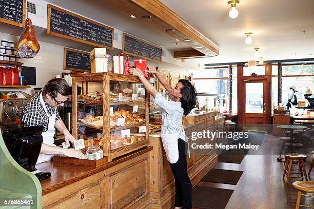 male and female workers in bakery going about business - jersey city stock pictures, royalty-free photos & images