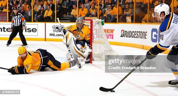 Vladimir Tarasenko of the St. Louis Blues looks to pass beyond the defense of Ryan Ellis of the Nashville Predators in front of goalie Pekka Rinne...