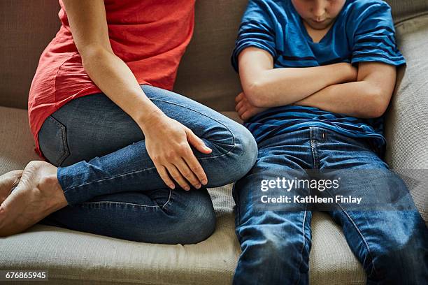 mother on sofa scolding son - strict parent imagens e fotografias de stock