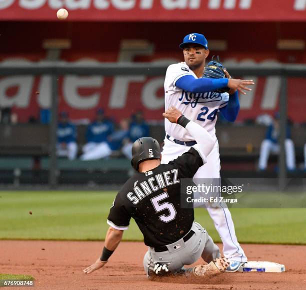 Christian Colon of the Kansas City Royals throws to first past Yolmer Sanchez of the Chicago White Sox for a double play in the first inning at...