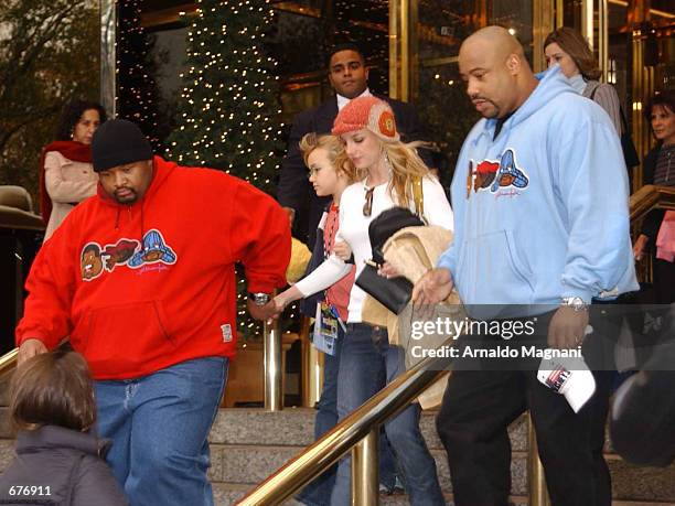 Singer Britney Spears holds hands with one of her bodyguards December 8, 2001 as she exits the Trump International Hotel in New York with her younger...