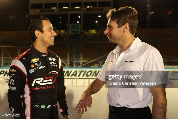 Helio Castroneves of Brazil, driver of the Team Penske Chevrolet talks with Will Power of Australia, driver of the Team Penske Chevrolet following...