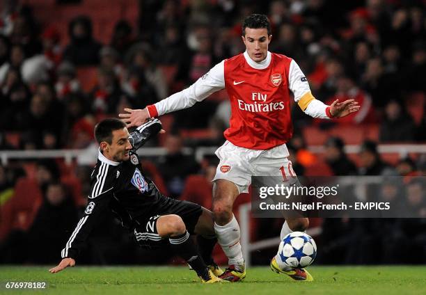 Partizan Belgrade's Aleksandar Davidov and Arsenal's Robin van Persie battle for the ball