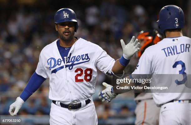 Franklin Gutierrez of the Los Angeles Dodgers is congratulated on his way to the dugout by teammate Chris Taylor after Gutierrez hit a solo homerun...