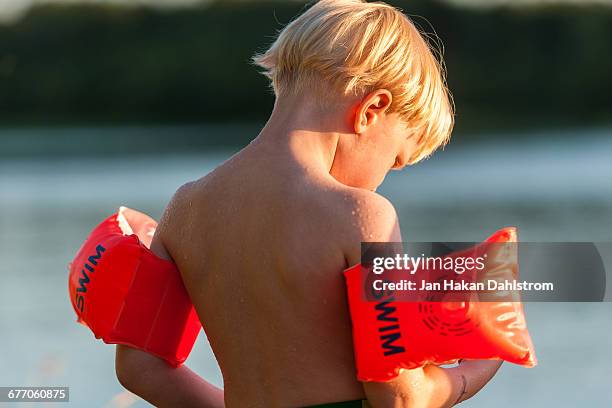 young boy by the sea in sunset - arm floats stock pictures, royalty-free photos & images