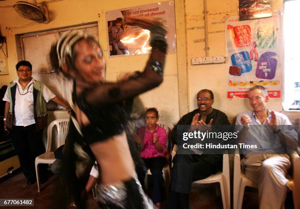 Ashok Rao Kavi and UNAIDS director Michel Sidibe watch an eunuch dance to Slumdog Millionaire's slongs at the Humsafar Trust drop in centre in Vakola.