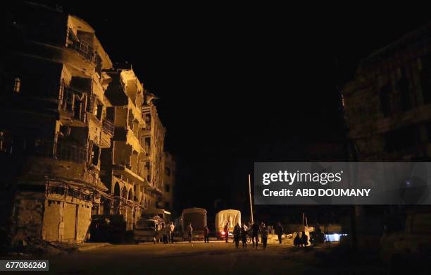 People unload supplies from a Syrian Arab Red Crescent truck part of a SARC and UN aid convoy in the rebel-held town of Douma, on the eastern...