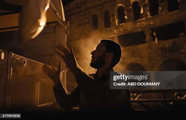 People unload supplies from a Syrian Arab Red Crescent truck part of a SARC and UN aid convoy in the rebel-held town of Douma, on the eastern...