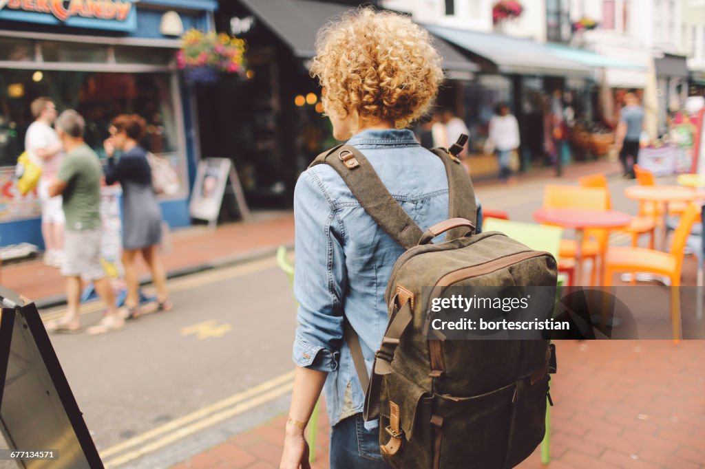 Vista traseira da mulher que anda na rua na cidade