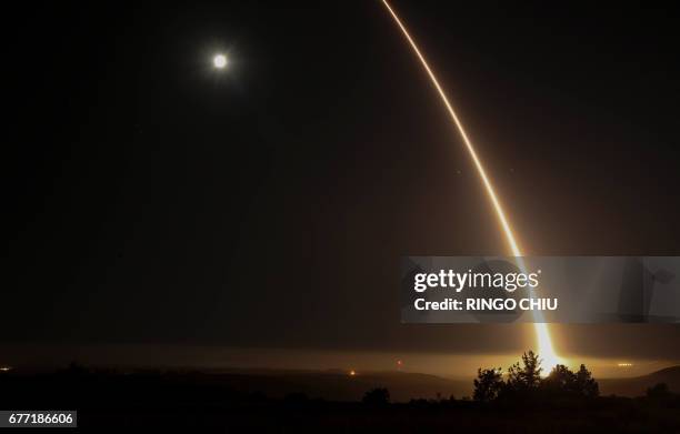 Streak of light trails off into the night sky as the US military test fires an unarmed intercontinental ballistic missile at Vandenberg Air Force...