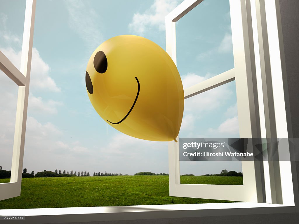 Smiley balloon flies away to the sky