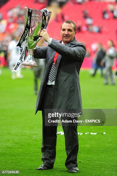 Swansea City manager Brendan Rodgers celebrates with the npower Championship Play-off Final trophy, after the final whistle