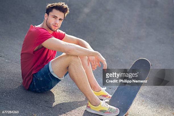 young men sitting with skateboard - philipp nemenz foto e immagini stock