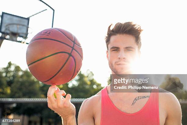 young men spinning basketball on finger - philipp nemenz foto e immagini stock