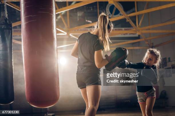 little girl practicing boxing with her coach in health club. - mixed martial arts stock pictures, royalty-free photos & images