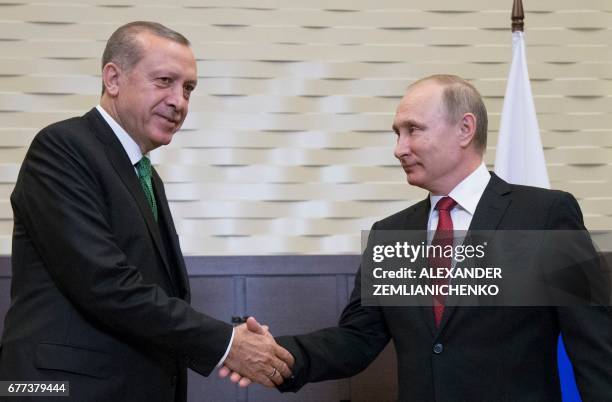 Russian President Vladimir Putin shakes hands with his Turkish counterpart Recep Tayyip Erdogan during their meeting at the Bocharov Ruchei state...