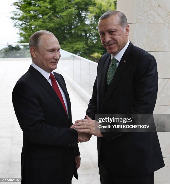 Russian President Vladimir Putin welcomes his Turkish counterpart Recep Tayyip Erdogan during their meeting at the Bocharov Ruchei state residence in...