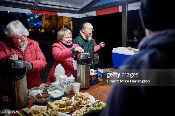 group of volunteers serving the homeless, smiling - soup kitchen stock pictures, royalty-free photos & images