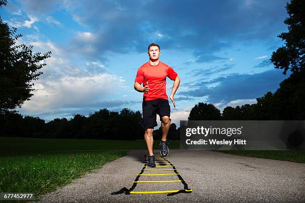 man working out at park doing exercises - agility ladder stock pictures, royalty-free photos & images