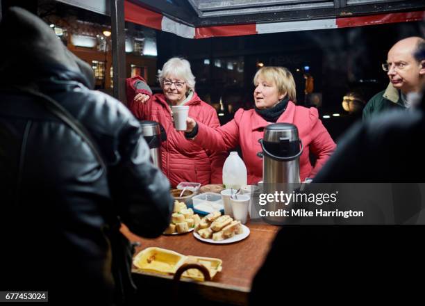 group of volunteers serving drinks to the homeless community - homelessness stock pictures, royalty-free photos & images