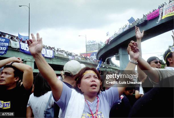 Woman gestures an "L" to symbolize "fight" during a prayer rally at the historic EDSA Shrine at suburban Mandaluyong for a rally January 17, 2001 in...