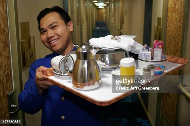 An Asian man holding a tray of food on the mms Noordam.