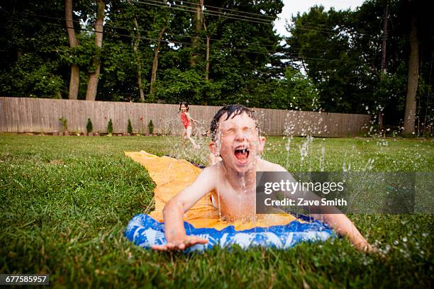 slip and slide - backyard water slide stock pictures, royalty-free photos & images