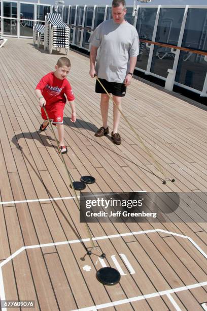 Father and son playing a game of shuffleboard on the mms Noordam.