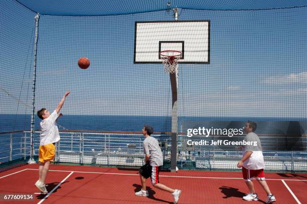 Group of boys playing a game of basketball on the Sports Deck of the mms Noordam.