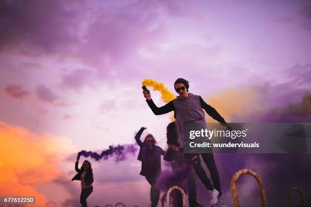 groupe de jeunes gens, faire la fête avec des bombes fumigènes multicolores - street party stock photos et images de collection