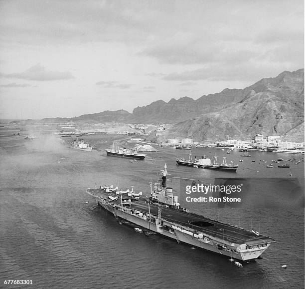 The Royal Navy Centaur-class light fleet aircraft carrier HMS Centaur with her straight axial flight deck at anchor in the Port of Aden whilst on...