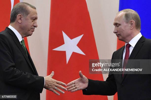 Russian President Vladimir Putin shakes hands with his Turkish counterpart Recep Tayyip Erdogan after a joint press conference following their...