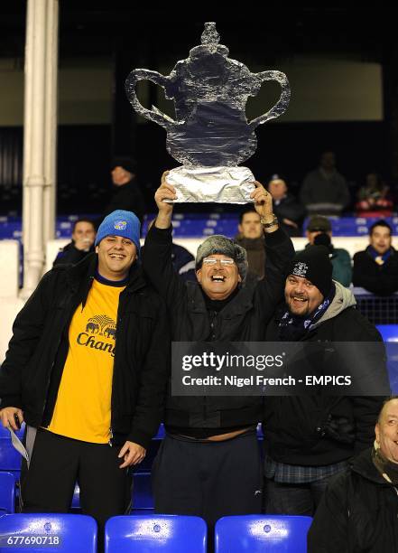 Everton fans hold up a homemade FA cup trophy in the stands