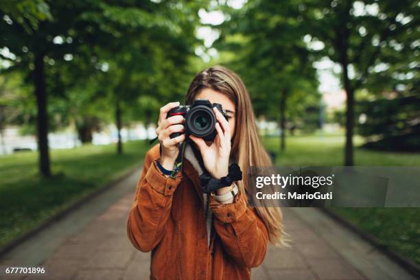 giovane donna che scatta una foto - oficio creativo foto e immagini stock